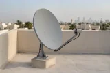 طبق استقبال فضائي وذراع استقبال مثبتان على سطح